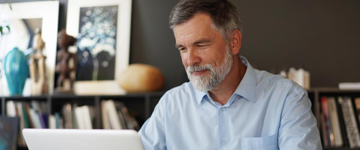 Fifty-year-old man working on laptop