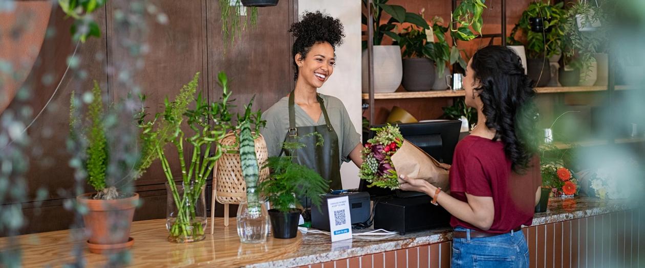 woman buying flowers from shop owner