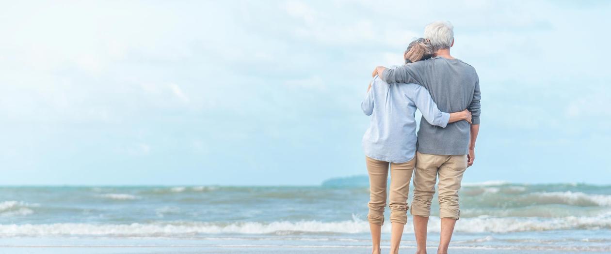 Retired couple walking on beach