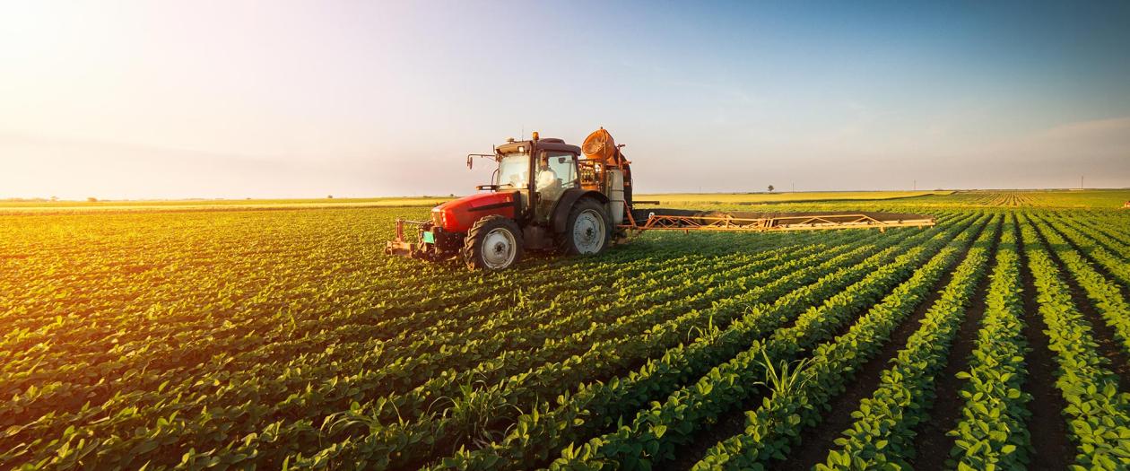 Tractor on field at sunset